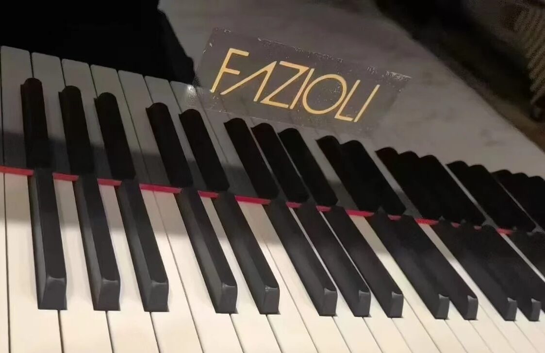 Klawiatura fortepianu Fazioli z widocznym logo włoskiej manufaktury i precyzyjną mechaniką