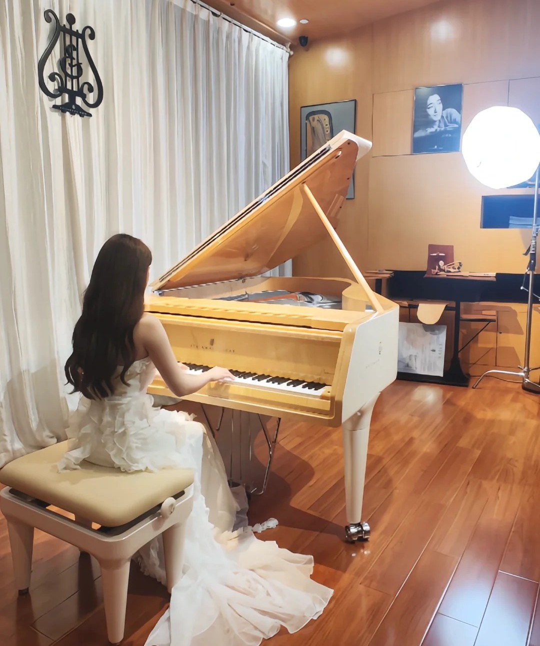 Pianistka w białej sukni grająca na jasnym fortepianie koncertowym w salonie