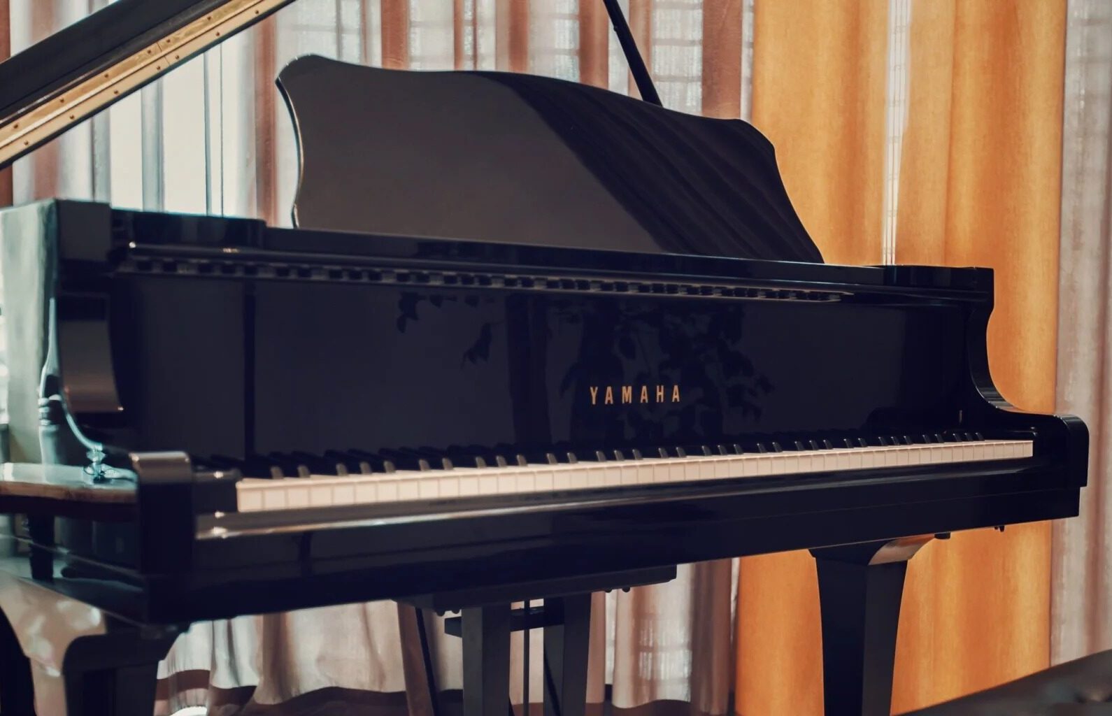 Czarny fortepian Yamaha z widocznym złotym napisem marki - japoński instrument klasyczny