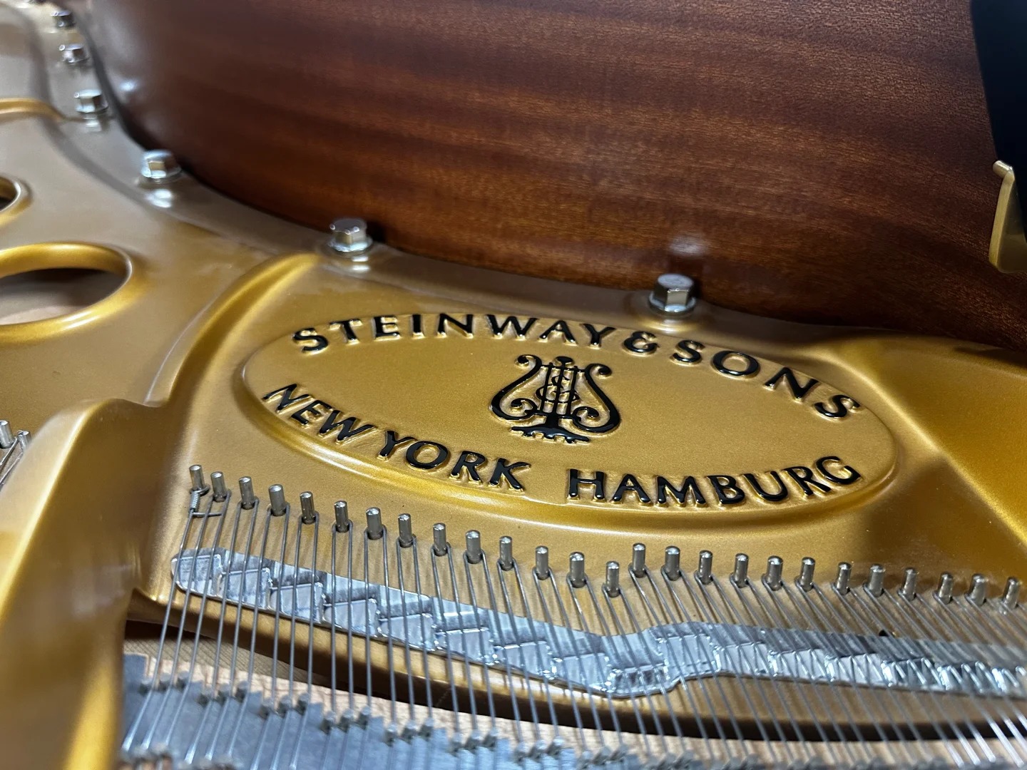 Złota plakietka Steinway & Sons New York Hamburg na ramie fortepianu koncertowego