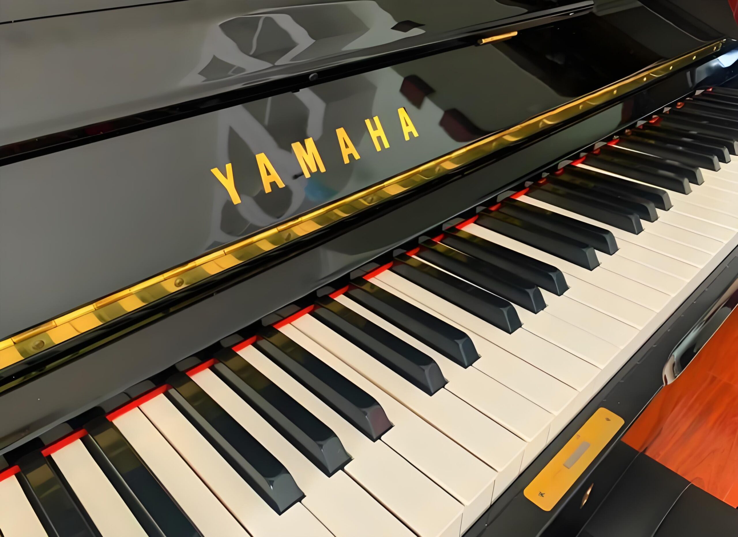 Klawiatura fortepianu Yamaha z widocznym złotym logo marki nad klawiszami