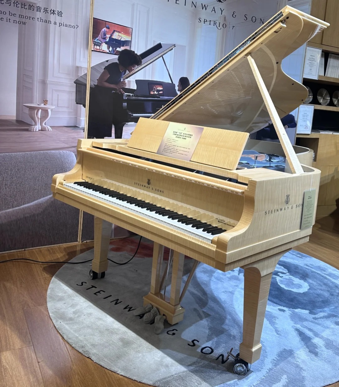 Piano à queue Steinway & Sons O-180 en bois clair dans un showroom